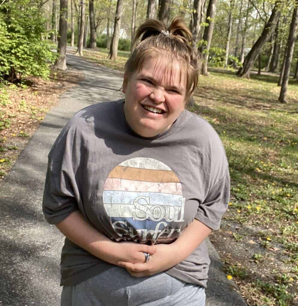 Bello Machre individual enjoying a walk in a park on a sunny day.