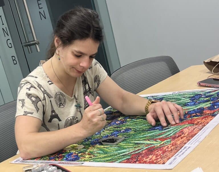 Bello self directed care recipient working on her craft artwork.