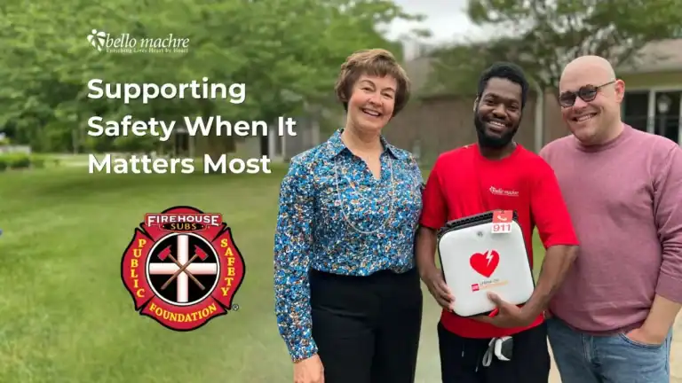 Development Team smiling with service recipient, holding up newly granted AED.