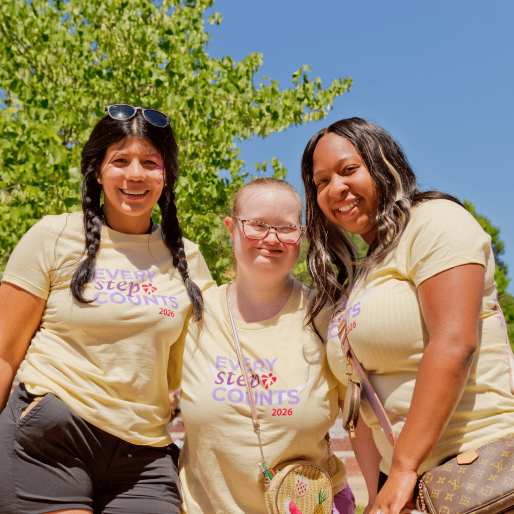 Bello Machre service recipient and two staff smiling in Yellow Every Step Counts shirts at Every Step Counts