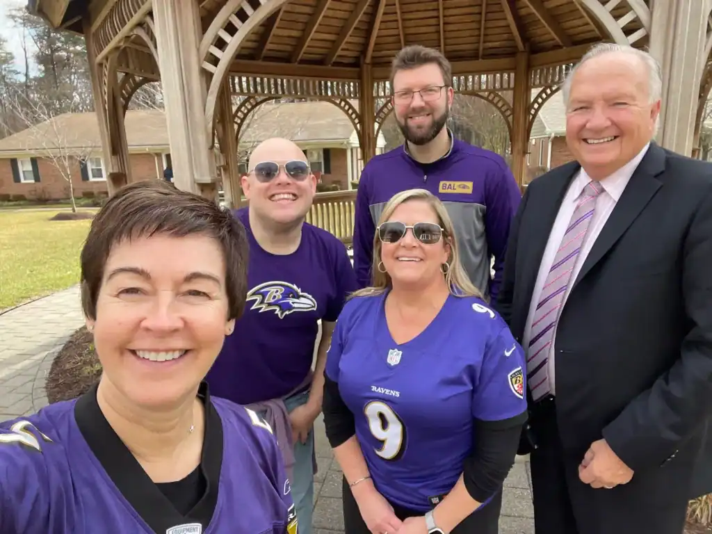 Chris with other members of the leadership team wearing Baltimore Ravens jerseys and colors.