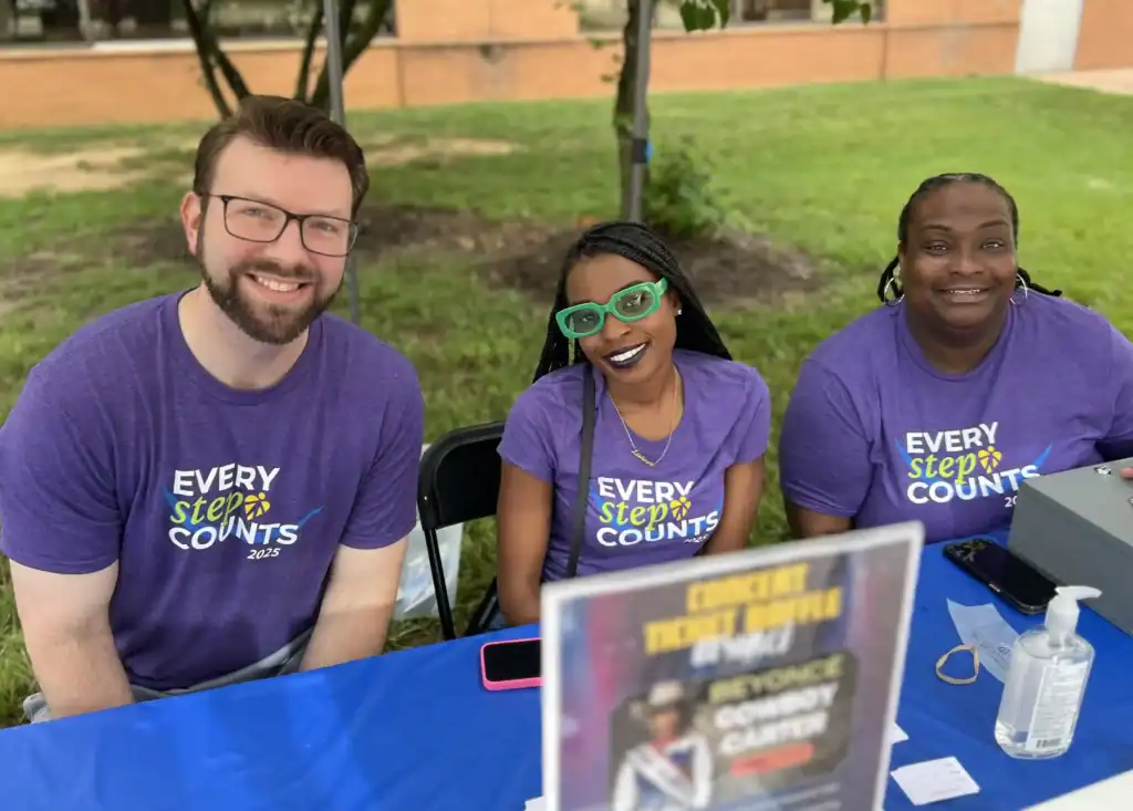Chris alongside other team members manning the information table at the Every Step Counts event.