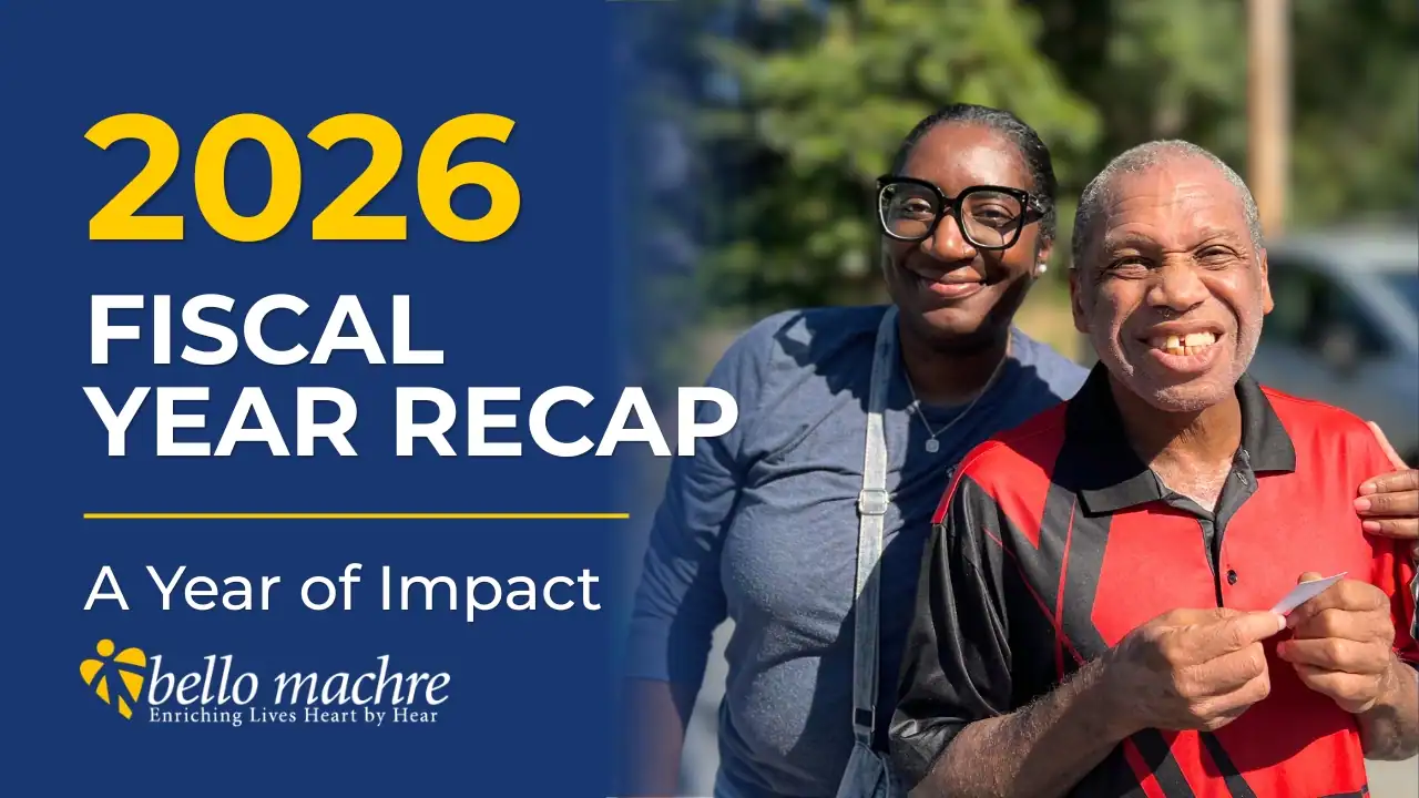 Man and support staff smiling in front of text that reads "2026 Fiscal Year Recap, A Year of Impact (Bello Machre).