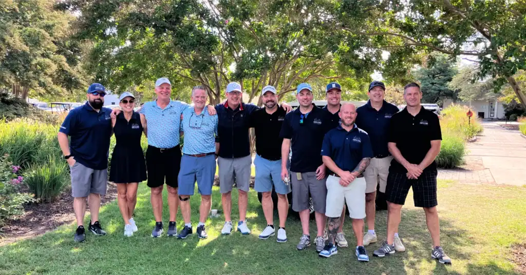 Group of golfers posing on the golf course.