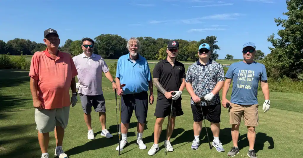 Group of golfers posing on the course.