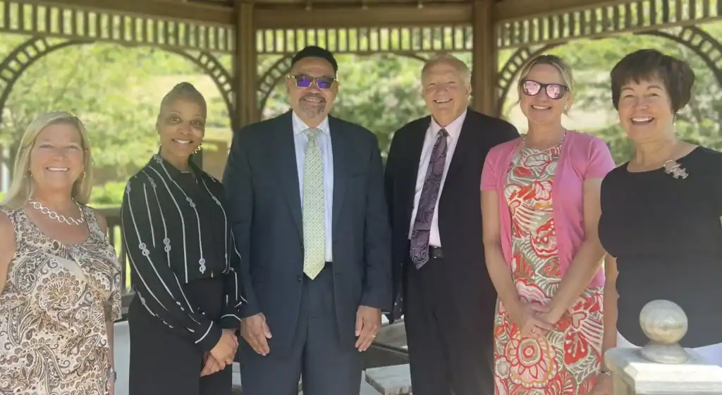 Bello Machre leadership standing with Maryland Department of Health and DDA representatives under a campus gazebo.
